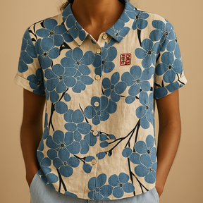 Vrouw draagt een luchtige blouse met vrolijke bloemenprint, ideaal voor zomerse dagen en casual outfits